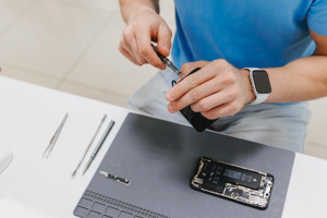 Un spécialiste en train de réparer un iphone dans un atelier de réparation